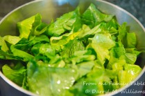 Chopped mustard greens cooking with oil, vinegar, and Louisiana hot sauce